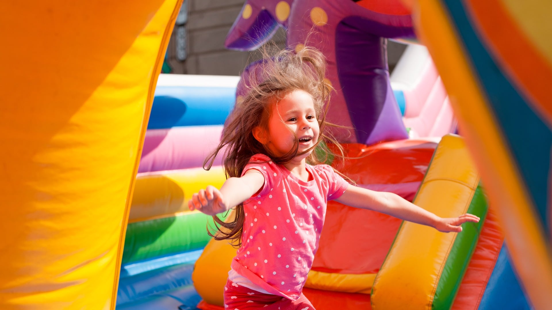 A cheerful child plays in an inflatable castle