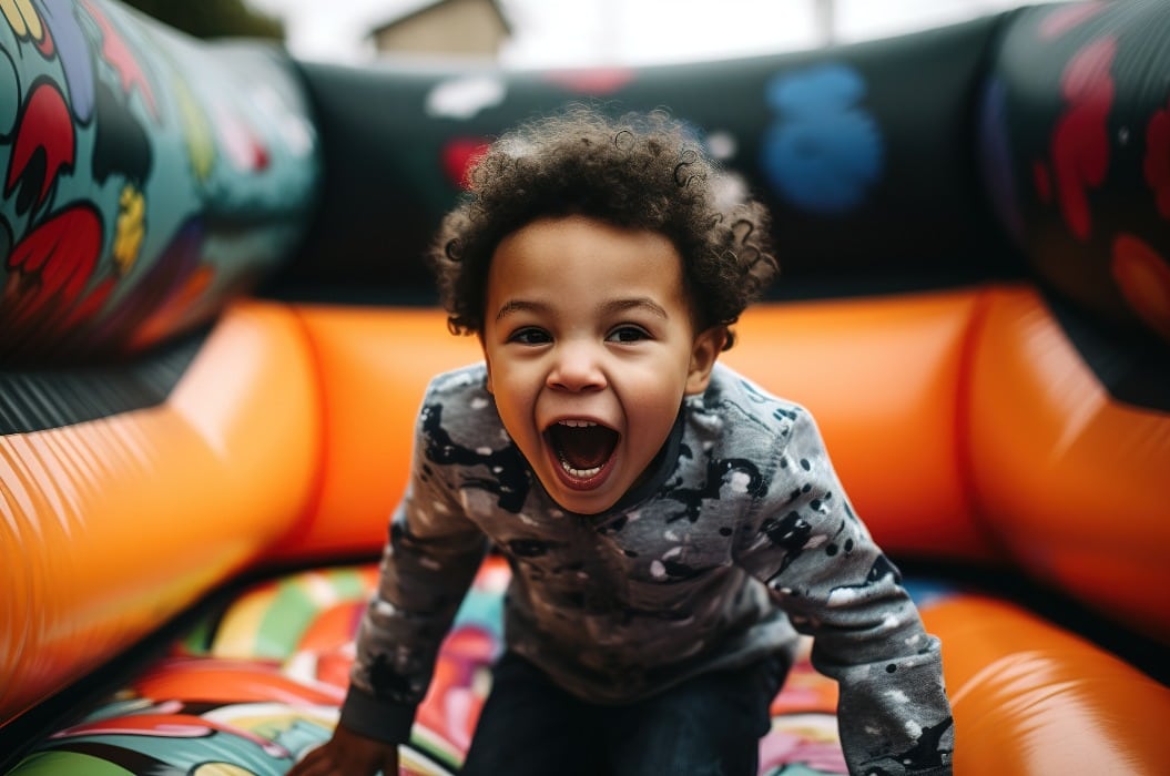 African American child playing and jumping in inflatable bouncy castle. Generative AI