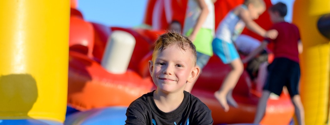 Smiling little boy sitting on a jumping castle