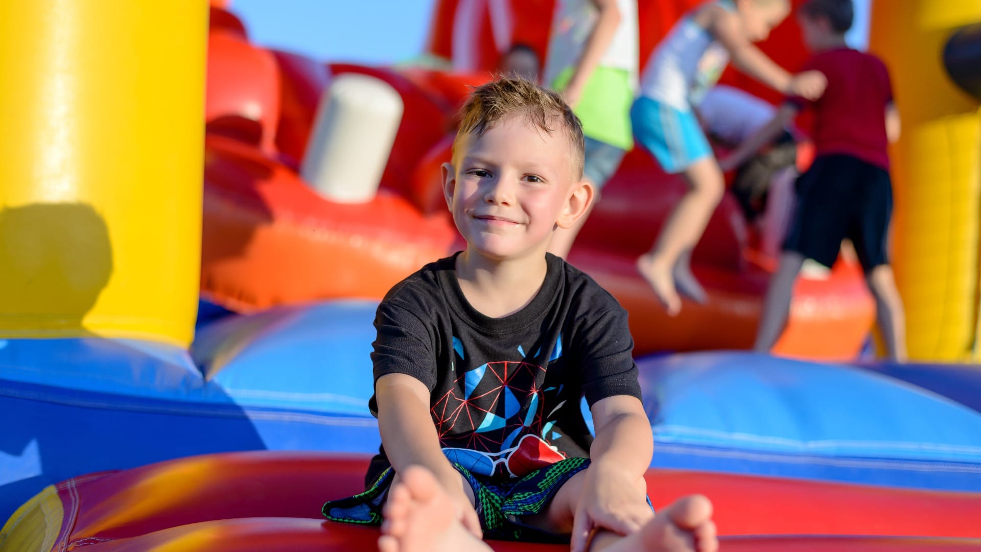 Smiling little boy sitting on a jumping castle