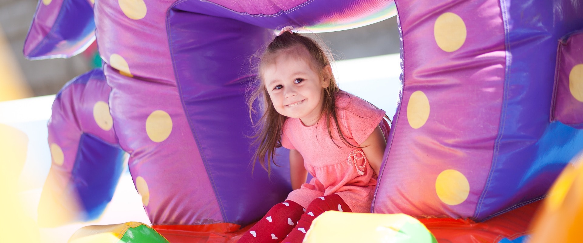 A cheerful child plays in an inflatable castle