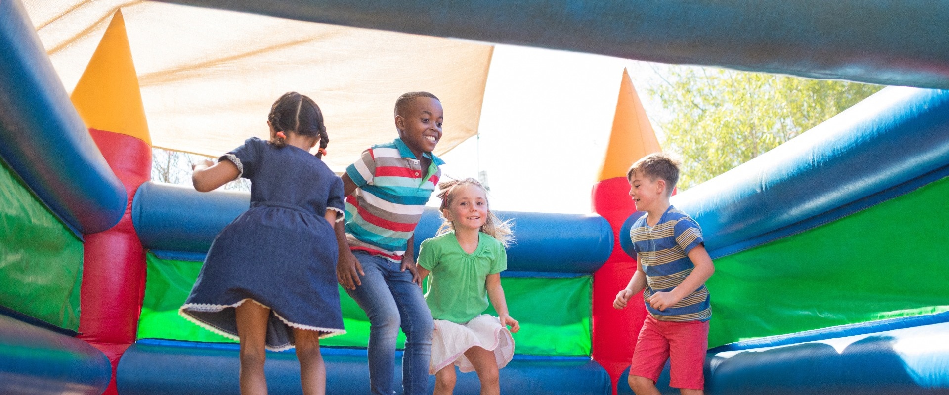 Friends playing on bouncy castle at playground