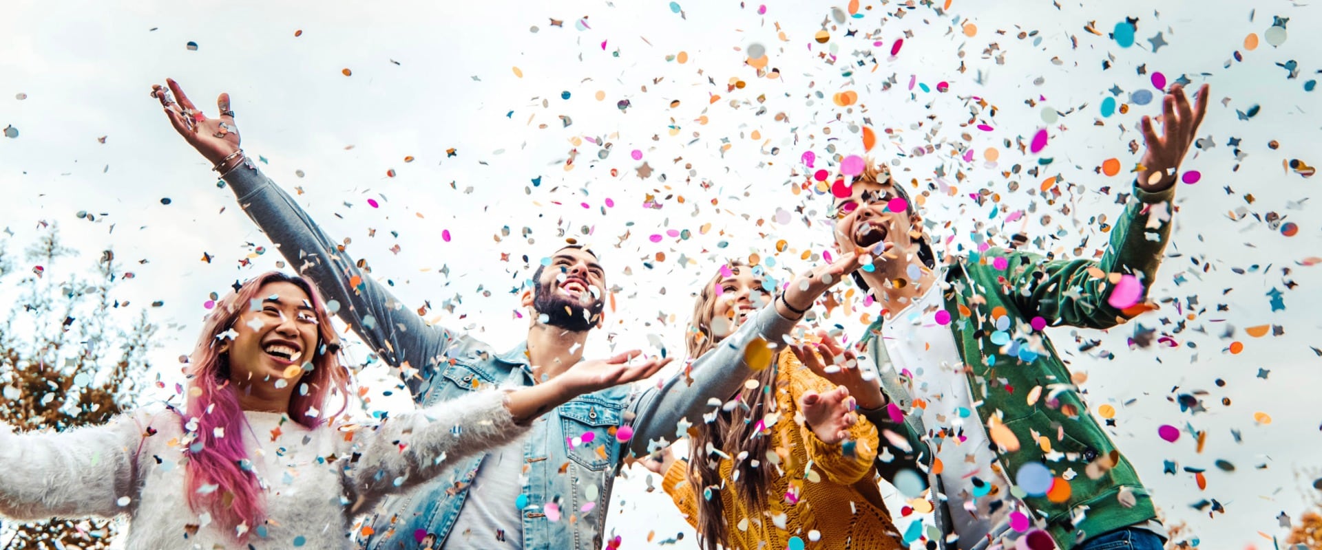 Happy friends celebrating throwing confetti in the air - Young people having outdoor party - Students having fun together at college campus - Youth culture concept