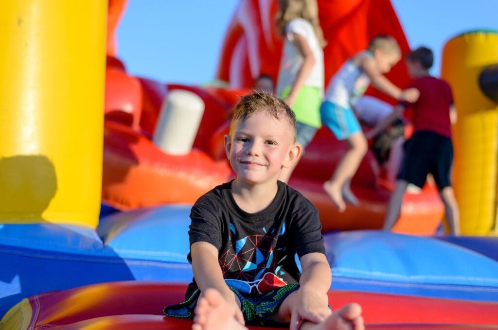 Smiling little boy sitting on a jumping castle