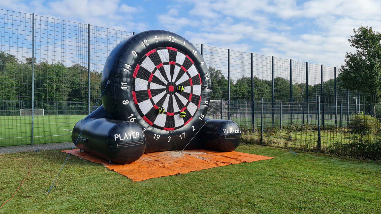 Aufblasbare Dartscheibe auf einem Sportplatz; Fußballweise Zielscheiben, grünem Rasen.