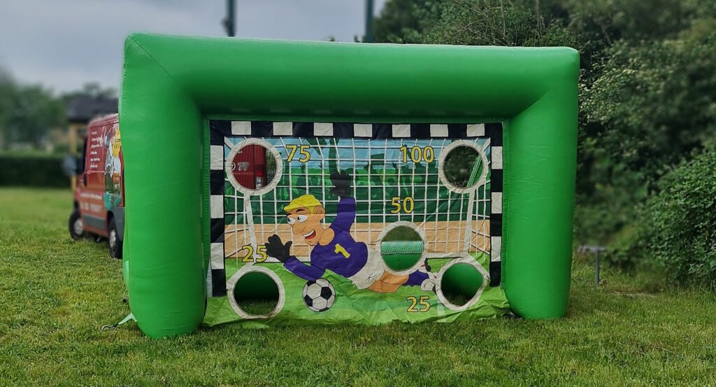 Aufblasbares Fußballtor in Grün mit Comic-Torwart. Punkte für Treffer in den Löchern angezeigt.