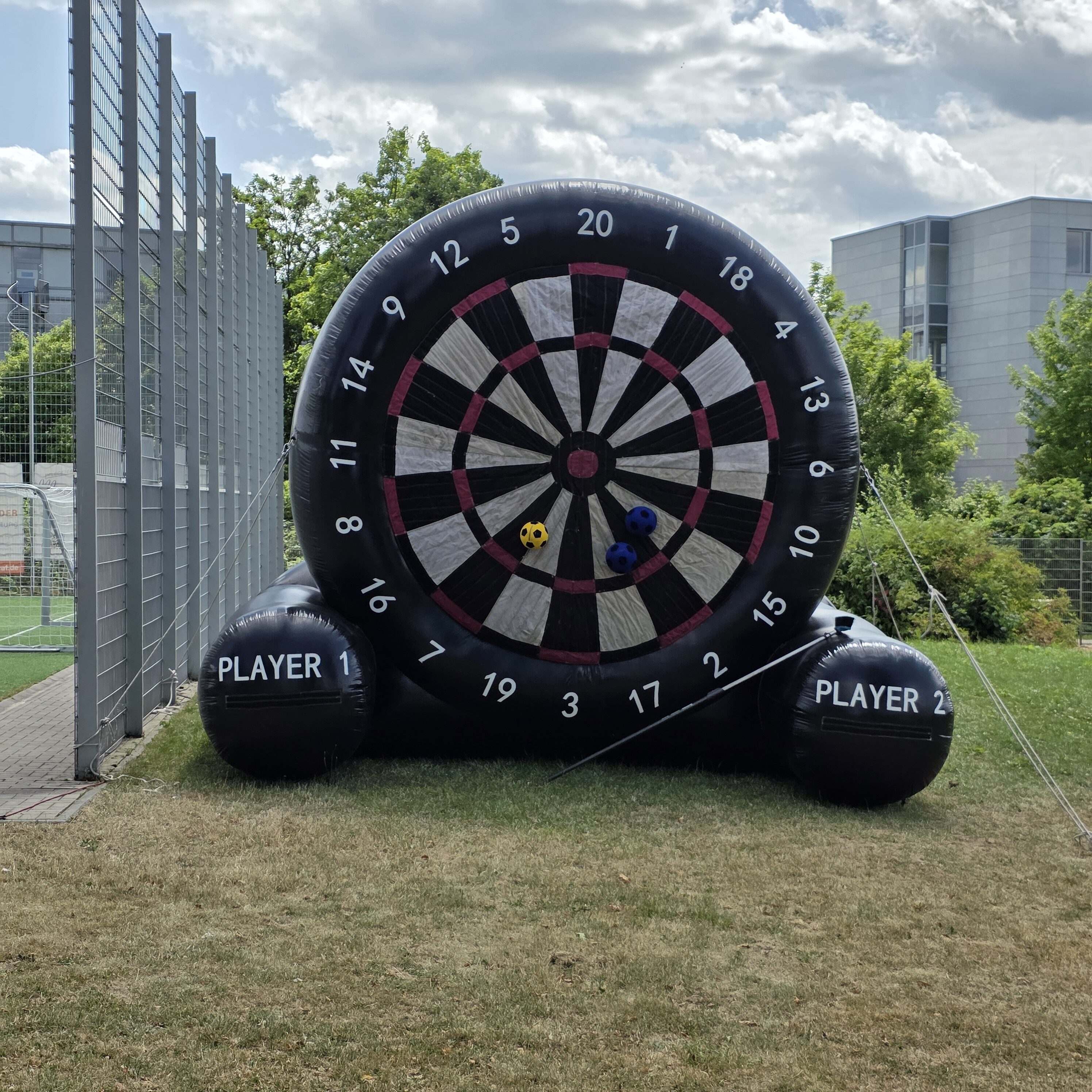 Riesige aufblasbare Dartscheibe mit Zahlen und Klettbällen im Freien.